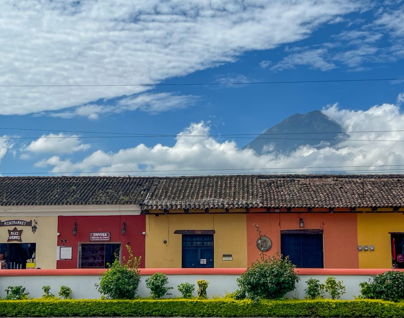 Case coloniali colorate ad Antigua con vulcano sullo sfondo