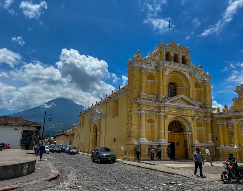 Chiesa gialla coloniale di Antigua con vulcano alle spalle