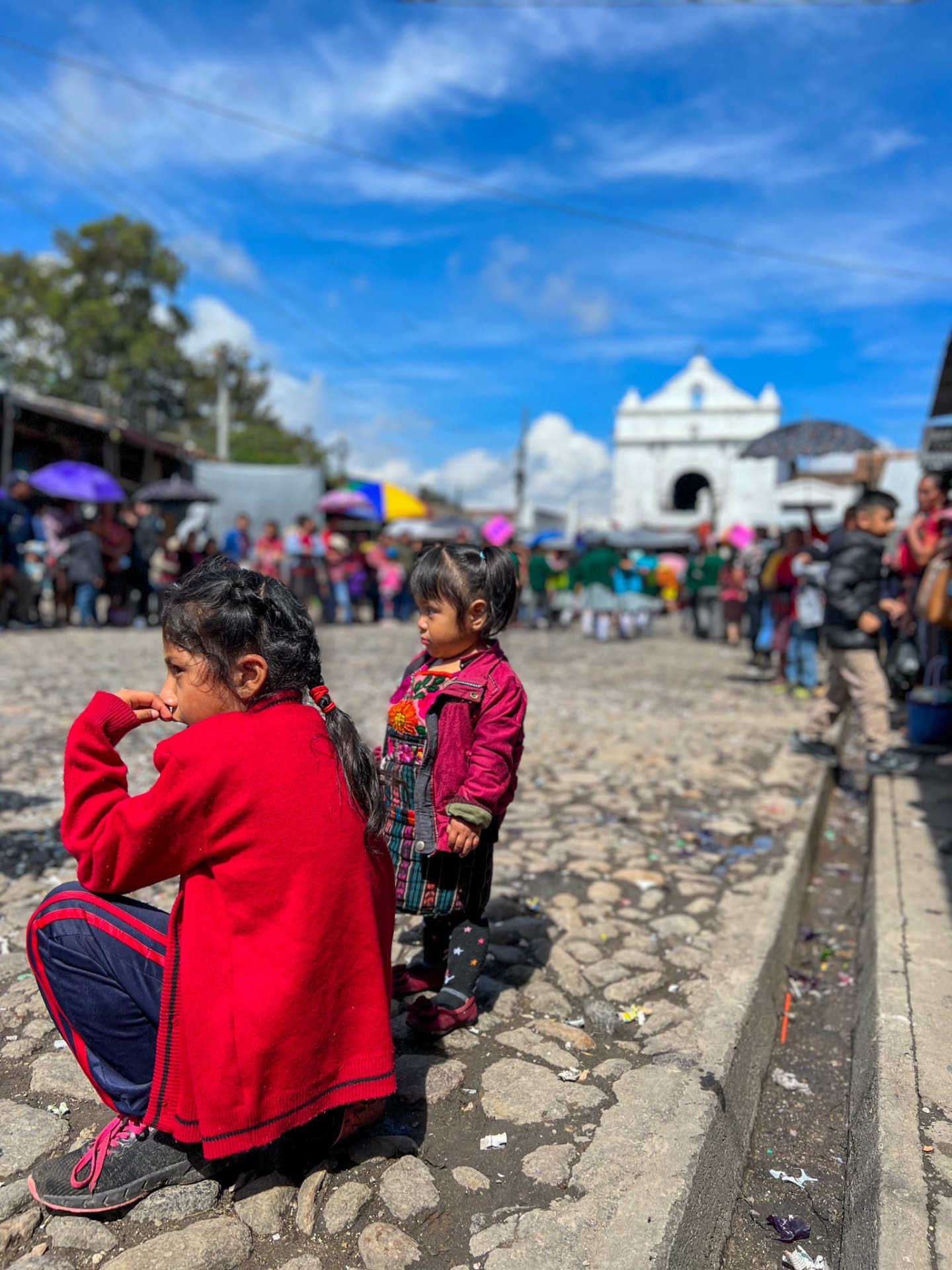 Due bambine maya in abiti tradizionali davanti alla chiesa bianca di Chichicastenango