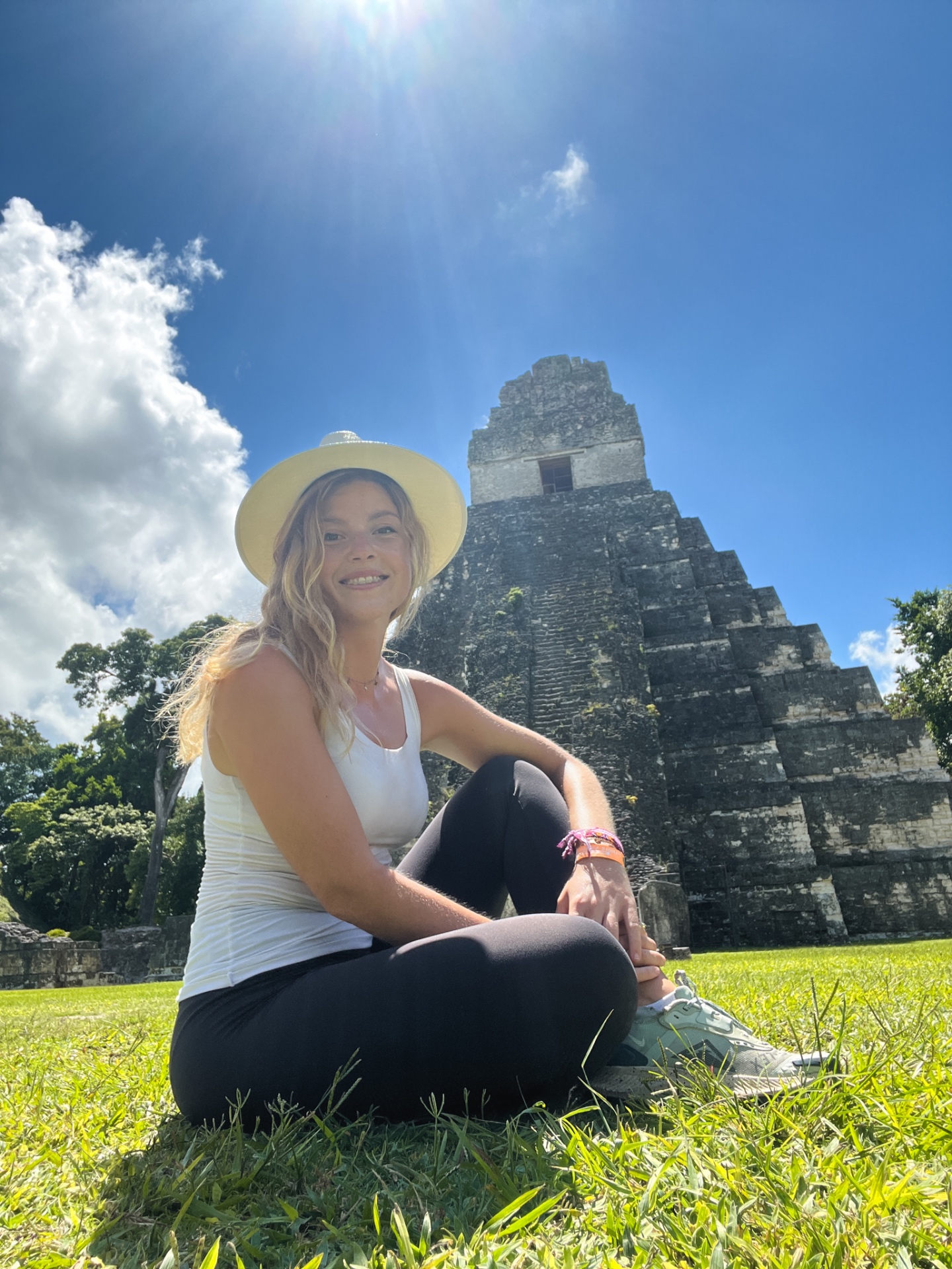 Donna seduta sul prato davanti al Tempio I di Tikal