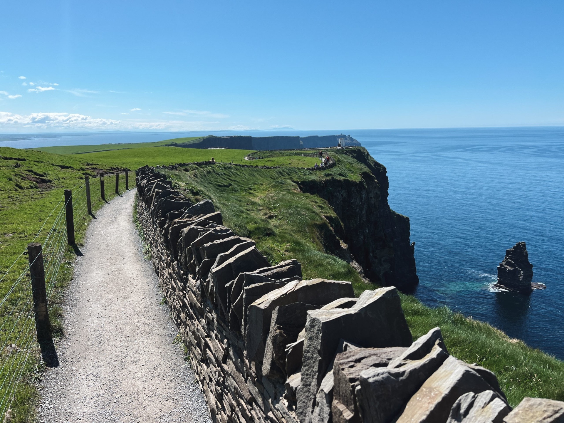 Sentiero lungo le Cliffs of Moher con muretto a secco e oceano sullo sfondo
