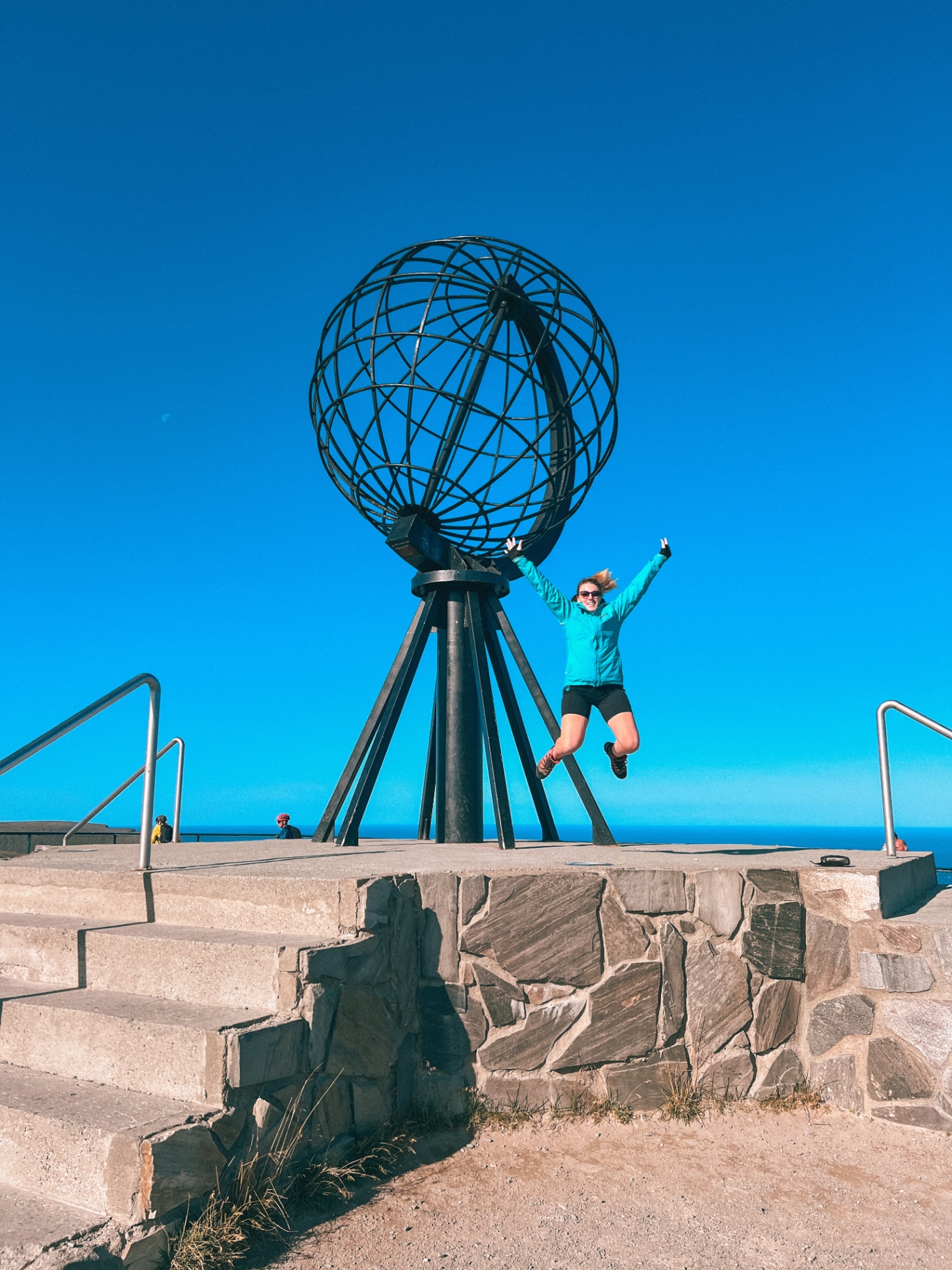 Salto di gioia davanti al globo di Capo Nord